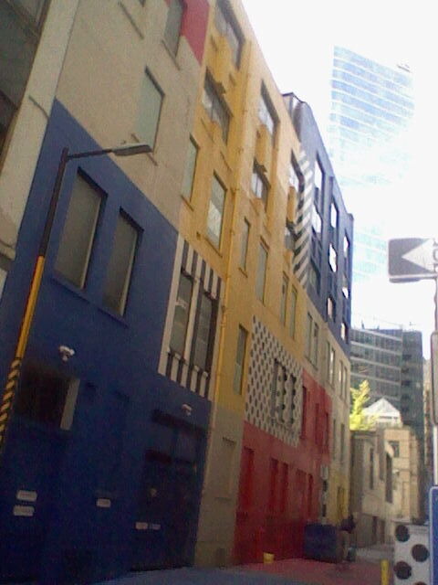 an alleyway, with one wall adorned in colorful patterns